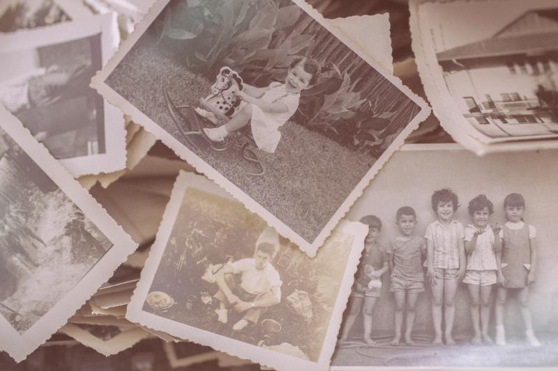 Scattered pile of sepia colored vintage photos of children.