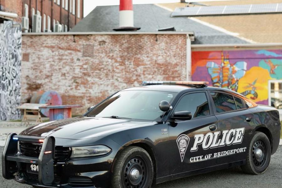 Photo of Bridgeport Police Department Cruiser outside of 305 Knowlton Street with mural and smokestack in background