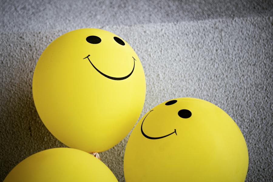 3 yellow balloons with smiley faces visible on 2 of them