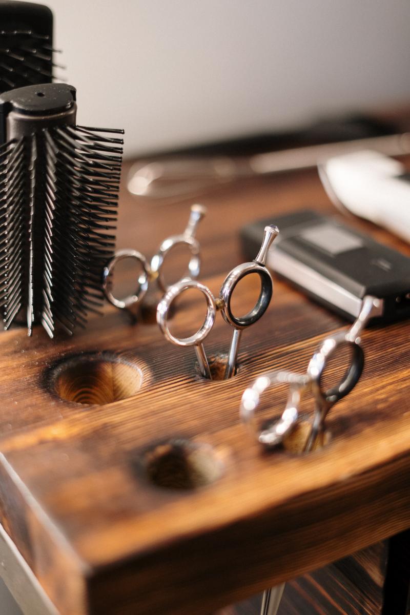 Hair scissors and brushes in a wooden organizer.