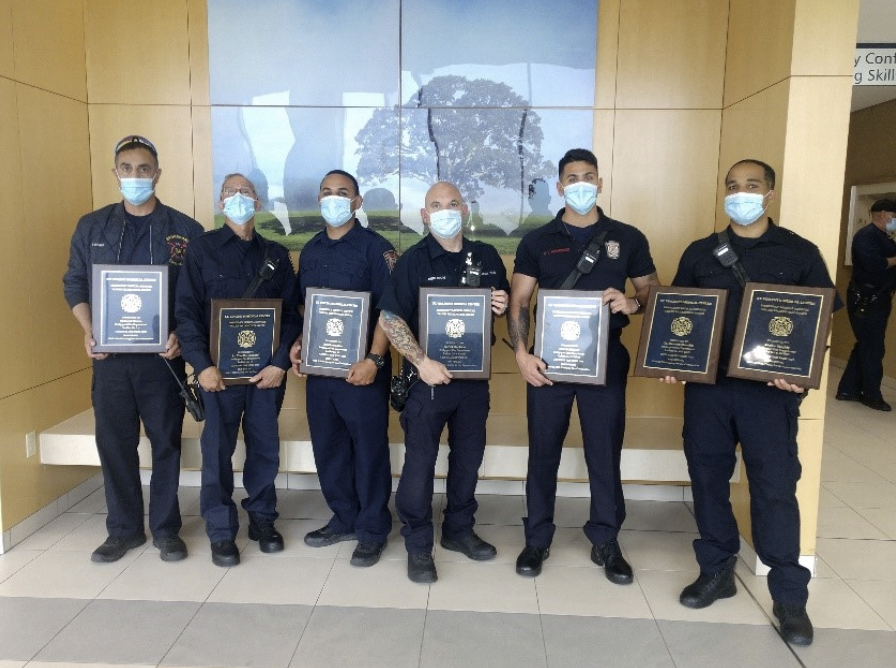 6 men stand in a line holding their EMS award plaques